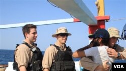 Para awak kapal perusak Angkatan Laut AS USS Kidd menyalami nelayan Iran di kapal Al Molai, setelah membebaskan mereka dari perompak Somalia (7/1).