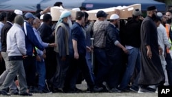 Mourners carry the body of a victim of the March 15 mosque shootings for burial at the Memorial Park Cemetery in Christchurch, New Zealand, March 20, 2019.
