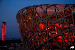 FILE - The National Stadium and the Beijing Olympic Tower are lit in red on the eve of the Chinese New Year, Jan. 31, 2022, China.