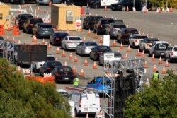 FILE - People, in their cars, wait in line for coronavirus testing at Dodger Stadium in Los Angeles, California, July 14, 2020.