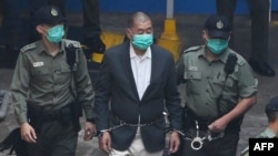 资料照：香港《壹传媒》创办人黎智英走向警车准备前往香港一家法院。(2020年12月12日)