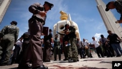Thai police investigate following an overnight shooting attack at Democracy Monument in Bangkok, Thailand, Thursday, May 15, 2014.