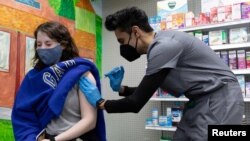 FILE - Julia Gadsby, 18, who has Lupus, receives the Pfizer-BioNTech vaccine against the coronavirus disease (COVID-19) at Skippack Pharmacy in Schwenksville, Pennsylvania, U.S., March 3, 2021. 