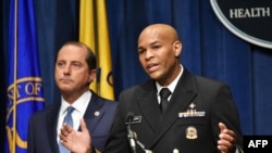 U.S. Surgeon General, Vice Admiral Jerome Adams, flanked by Health and Human Services Secretary Alex Azar, briefs the media on the release of a warning against marijuana use by adolescents and pregnant women, in Washington, Aug. 29, 2019. 