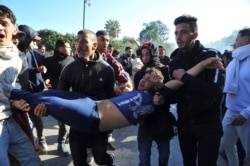 FILE - A wounded protester is evacuated during a demonstration to denounce then-President Abdelaziz Bouteflika's bid for a fifth term, in Algiers, Algeria, Feb. 23, 2019.