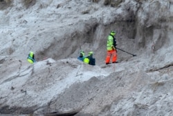 FILE - Zimbabwean citizens work on a mined beach in Stanley, Falkland Islands (Malvinas), Oct. 11, 2019.