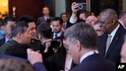 资料照：在新加坡的香格里拉安全对话会上，美国国防部长奥斯汀与中国防长李尚福握手并短暂交流。（2023年6月2日）