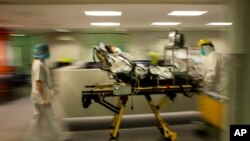 FILE - Medical staff move a COVID-19 patient at the CHR Citadelle hospital in Liege, Belgium, Oct. 21, 2020. 