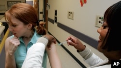 FILE - A woman gets a flu shot on the Emory University campus in Atlanta, Georgia. 
