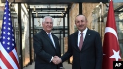 Turkish Foreign Minister, Mevlut Cavusoglu shakes hands with U.S. Secretary of State Rex Tillerson, left, during their meeting in Istanbul, Sunday, July 9, 2017. Secretary of State Rex Tillerson accepts a prize from a global petroleum conference, back in the company of the oil men and authoritarian governments he made his career with. 