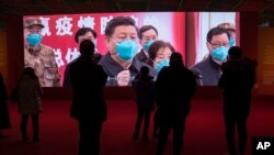 FILE - Residents attend an exhibition on the city's fight against the coronavirus in Wuhan in central China's Hubei province, Jan. 23, 2021.