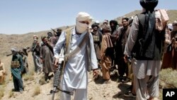 FILE - Members of a Taliban breakaway faction walk during a gathering, in Shindand district of Herat province, Afghanistan, May 27, 2016.