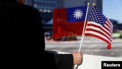 ARSIP – Seorang pengunjuk rasa mengibarkan bendera Taiwan dan AS sebagai bentuk dukungan terhadap Presiden Taiwan, Tsai Ing-wen, selama persinggahannya dalam kunjungan ke Amerika Latin di Burlingame, California, AS, 14 Januari 2017 (foto: REUTERS/Stephen Lam)