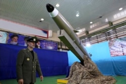 FILE - In this photo released by the official website of the Iranian Defense Ministry Aug. 13, 2018, Defense Minister Gen. Amir Hatami walks past a missile display at an undisclosed location in Iran.