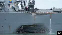 FILE - damage is visible as the guided-missile destroyer USS John S. McCain steers towards Changi naval base in Singapore following a collision with the merchant vessel Alnic MC. 