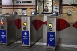 A transit worker is seen wearing a face mask inside a mostly empty city center train station during a lockdown in Sydney, Australia, June 29, 2021.