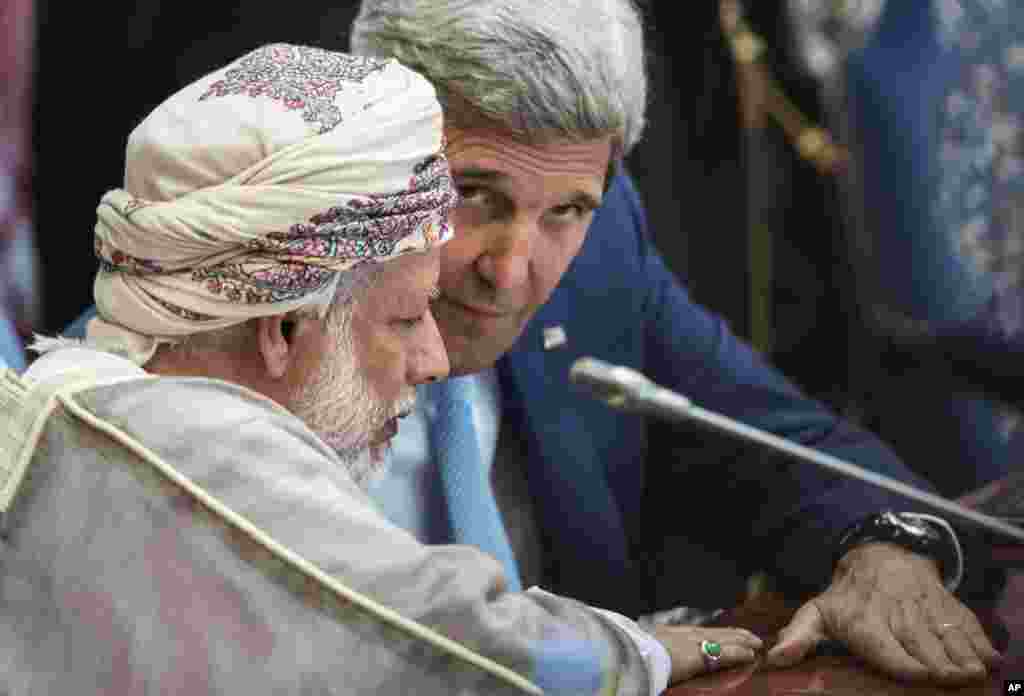 Oman's Foreign Minister Yusuf bin Alawi bin Abdullah and U.S. Secretary of State John Kerry talk before a meeting of the Gulf Arab region, Jeddah, Saudi Arabia, Sept. 11, 2014.