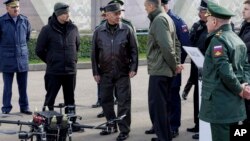 Фото від Міноборони Росії: міністр оборони Сергій Шойгу (у центрі) відвідує полігон Московського військового округу для перевірки виконання вказівок з розробки безпілотних літальних апаратів, 20 квітня 2024 р. Russian Defense Ministry Press Service via AP