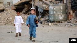 Falastinlik bola G'azo Sektorining Xon-Yunus shahrida Qurbon hayiti namoziga ketyapti, 16-iyun, 2024-yil