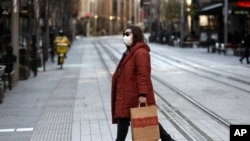 A woman crosses a normally busy street in Sydney, July 7, 2021.