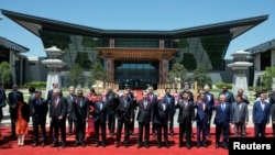 Leaders attending the Belt and Road Forum wave as they pose for a group photo at the Yanqi Lake venue on the outskirt of Beijing, China, May 15, 2017. 