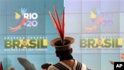 Mahalliy aholi vakillaridan biri Rio+20 konferensiyasiga bag'ishlangan plakat oldida.