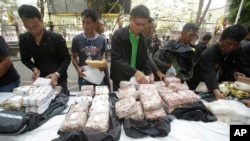 FILE - Thai policemen display intercepted drugs - 226 kilograms (498 pounds) of crystal meth and 8 kilograms (18 pounds) of heroin - during press a conference in Bangkok, Thailand.