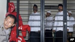Indonesian Muslims who are on trial for their involvement in a fatal attack against followers of a minority Islamic sect earlier this year wait for the start of the hearing at a district court in Serang, Banten province, Indonesia, July 28, 2011