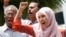 FILE - Nurul Izzah Anwar, right, daughter of imprisoned Malaysian opposition leader Anwar Ibrahim, leads a chant in Kuala Lumpur, March 17, 2015. 