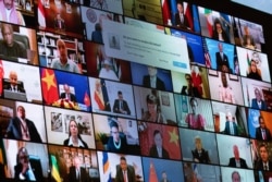 FILE - World leaders are shown on a screen as President Joe Biden speaks to the virtual Leaders Summit on Climate, from the East Room of the White House, April 23, 2021.