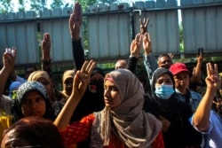 People flash three-finger salutes as they attend a funeral of U Khin Maung Latt, 58, a National League for Democracy (NLD)'s ward chairman, in Yangon, Myanmar, March 7, 2021.