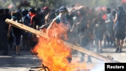 A demonstrator sets a barricade on fire during a protest against Chile's state economic model in Santiago, Oct. 24, 2019. 