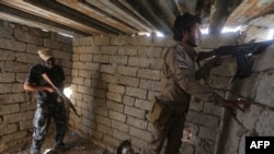 Iraqi Sunni fighters battling Islamic State (IS) group jihadists alongside government forces keep their position on the outskirts of Iraq's Baiji oil refinery, about 200 kilometers north of Baghdad, on May 25, 2015