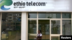 FILE - A woman walks past an Ethio Telecom office in Ethiopia's capital, Addis Ababa, Nov. 9, 2015.