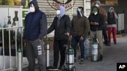 Stanovnici Meksiko Sitija čekaju u redu da napune boce sa kiseonikom za članove porodica, obolele od koronavirusa, 31. decembar 2020. (Foto: AP/Marco Ugarte)