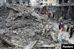 Palestinci stoje pored ruševina zgrade uništene u izraelskom udaru, u Kan Junisu, na jugu Pojasa Gaze, 10. oktobra 2023.