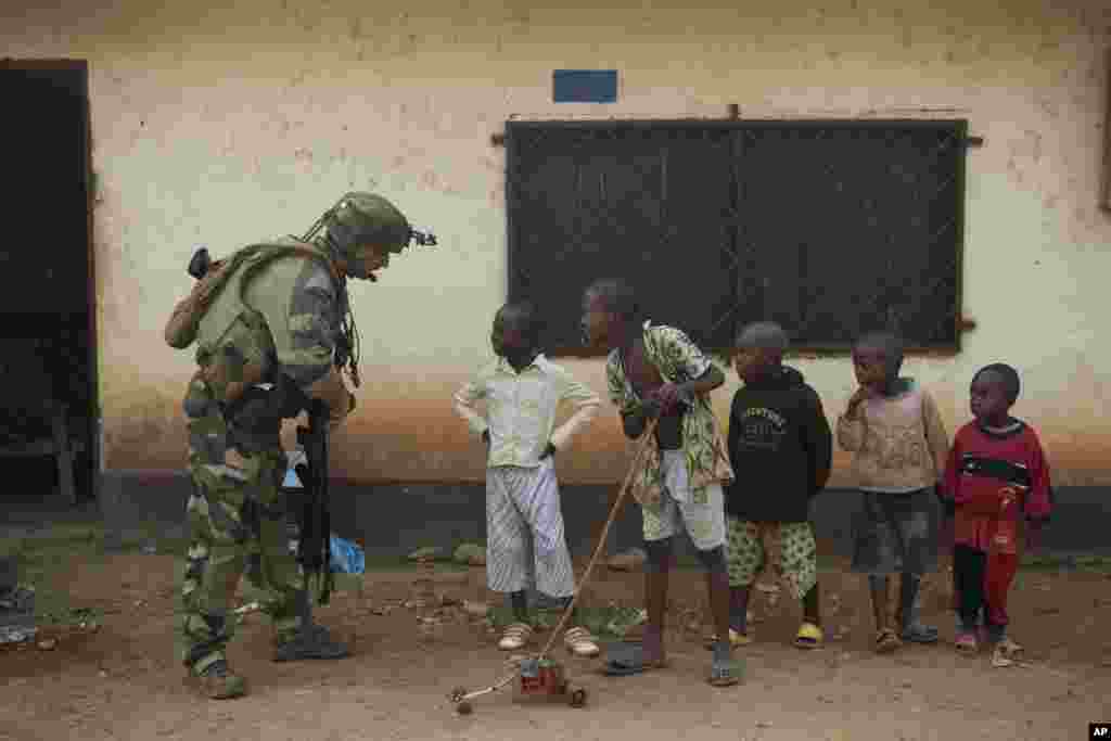 A French soldier talks to curious children as he mans a roadblock in the Miskine neighborhood of Bangui, Central African Republic, Jan. 6, 2014. 
