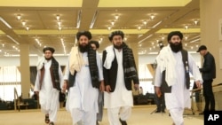 FILE - Members of Afghanistan's Taliban delegation arrive for the signing of an agreement between the Taliban and U.S. officials, in Doha, Qatar, Feb. 29, 2020.